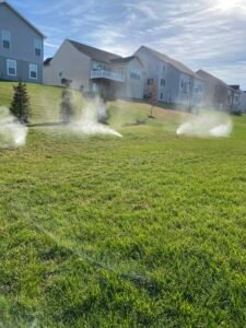 Professional copper backflow preventer installation with irrigation system and landscaped residential property by Advanced Irrigation & Lighting Services serving Northern Virginia, Washington D.C., and Montgomery County, Maryland.