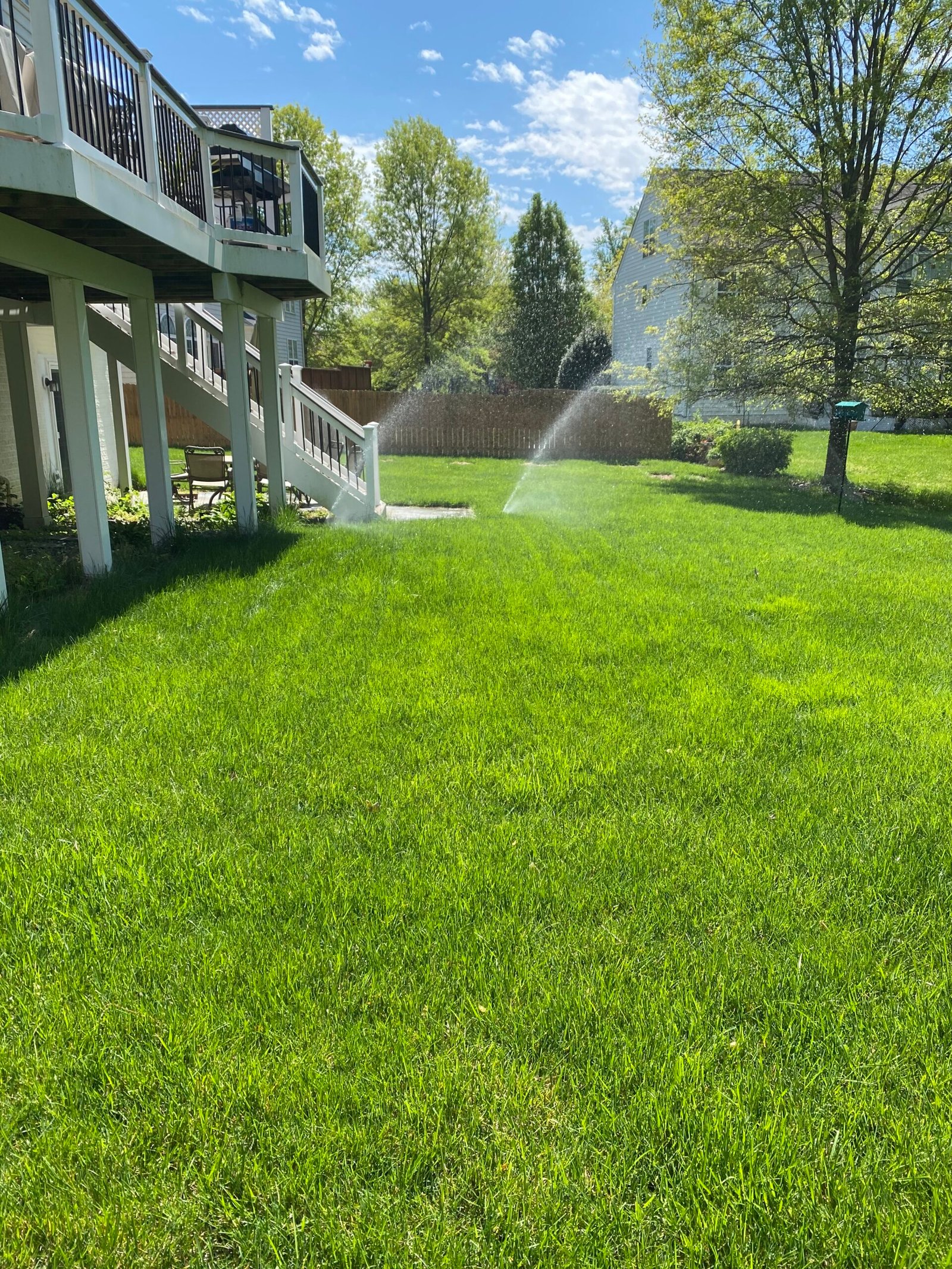 Professional copper backflow preventer installation with irrigation system and landscaped residential property by Advanced Irrigation & Lighting Services serving Northern Virginia, Washington D.C., and Montgomery County, Maryland.