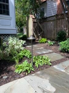 Professional copper backflow preventer installation with irrigation system and landscaped residential property by Advanced Irrigation & Lighting Services serving Northern Virginia, Washington D.C., and