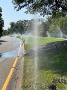 Professional copper backflow preventer installation with irrigation system and outdoor landscaping at a residential property by Advanced Irrigation & Lighting Services.