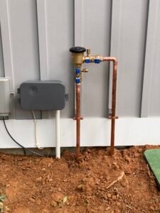 Certified technician performing backflow testing on a residential irrigation backflow preventer in Northern Virginia.