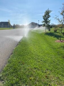 Technician performing a spring turn-on service for a residential sprinkler irrigation system in Northern Virginia.