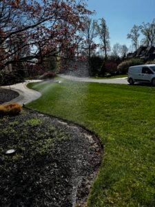 Technician performing sprinkler maintenance on a residential irrigation system in Northern Virginia.