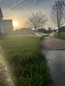 Technician winterizing a residential sprinkler irrigation system with compressed air in Northern Virginia.